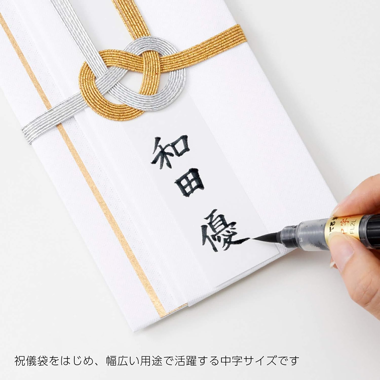 Hand writing Japanese calligraphy on a decorative envelope with a Pentel Fude brush pen